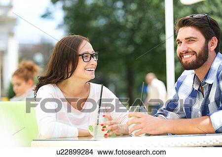 Picture - Cheerful couple having mojito at sidewalk cafe. Fotosearch