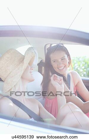 Cheerful female friends enjoying road trip in car View Large Photo Image Stock Photo - Cheerful female friends enjoying road trip in car. Fotosearch