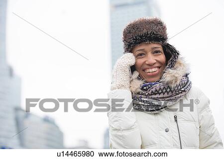 Cheerful woman in winter wear using cell phone outdoors View Large Photo Image Stock Image - Cheerful woman in winter wear using cell phone outdoors. Fotosearch