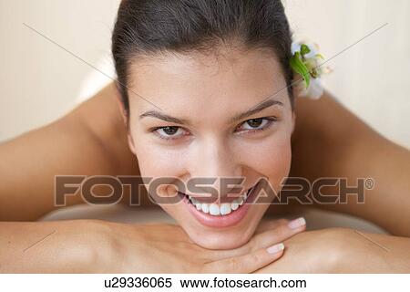 Stock Photography - Close-up of cheerful young woman relaxing on massage table. Fotosearch