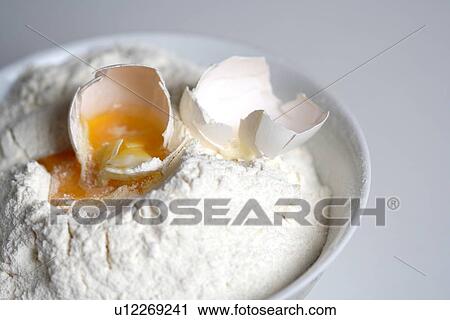 Stock Image - Close up of egg and flour. Fotosearch