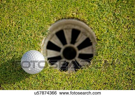 Close-up of golf ball near hole View Large Photo Image Stock Photograph - Close-up of golf ball near hole. Fotosearch