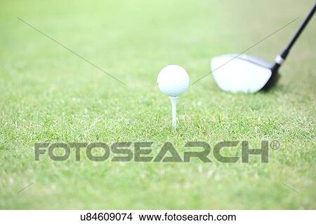 Picture - Close-up of golf club and tee with ball on grass. Fotosearch