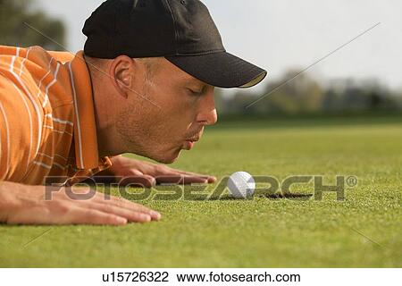 Close-up of man blowing on golf ball View Large Photo Image Stock Image - Close-up of man blowing on golf ball. Fotosearch