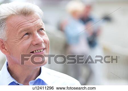 Stock Photograph - Close-up of smiling man looking away outdoors. Fotosearch