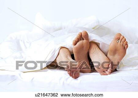 Close-up of the feet of a couple on the bed View Large Photo Image Stock Image - Close-up of the feet of a couple on the bed. Fotosearch