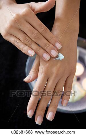 Close-up of woman rubbing lotion on hands View Large Photo Image Stock Photo - Close-up of woman rubbing lotion on hands. Fotosearch