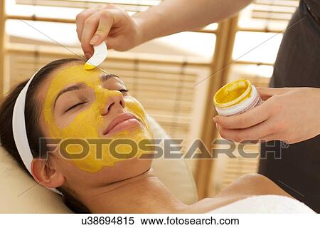 Stock Photography - Close-up of young woman having facial mask in beauty parlor. Fotosearch
