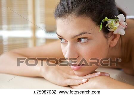 Stock Image - Close-up of young woman relaxing on massage table. Fotosearch