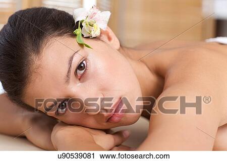 Stock Image - Close-up of young woman relaxing on massage table. Fotosearch