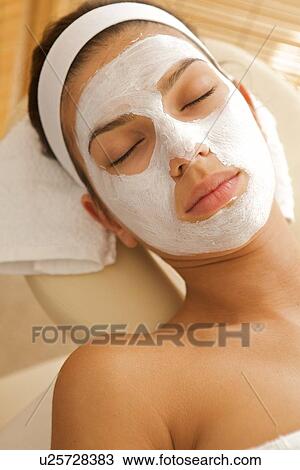 Stock Image - Close-up of young woman wearing facial mask. Fotosearch