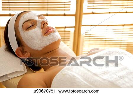 Stock Image - Close-up of young woman wearing facial mask. Fotosearch
