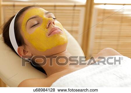 Stock Photo - Close-up of young woman wearing facial mask. Fotosearch