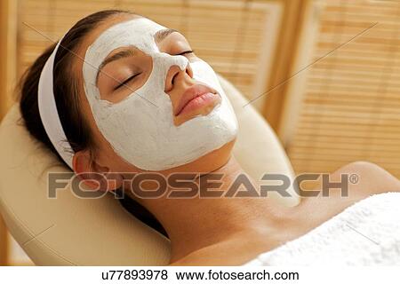 Stock Photo - Close-up of young woman wearing facial mask. Fotosearch