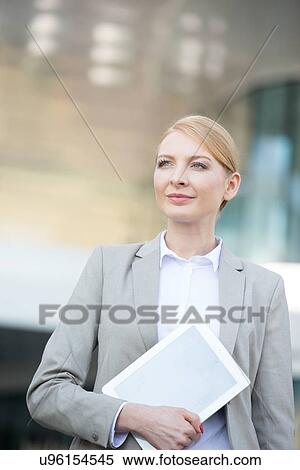 Stock Photography - Confident businesswoman holding digital tablet outdoors. Fotosearch