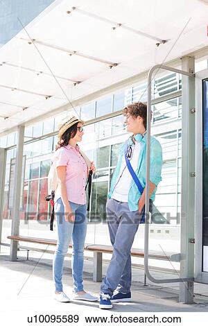 Couple communicating while waiting at bus stop View Large Photo Image Stock Photo - Couple communicating while waiting at bus stop. Fotosearch