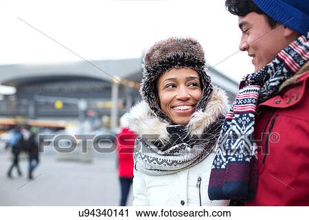 Couple talking while walking in city during winter View Large Photo Image Stock Image - Couple talking while walking in city during winter. Fotosearch