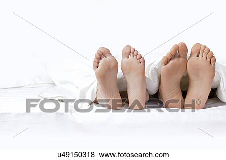 Couple's feet on the bed View Large Photo Image Stock Photo - Couple's feet on the bed. Fotosearch