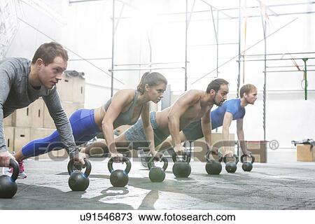 Dedicated people doing pushups with kettlebells at crossfit gym View Large Photo Image Stock Image - Dedicated people doing pushups with kettlebells at crossfit gym. Fotosearch