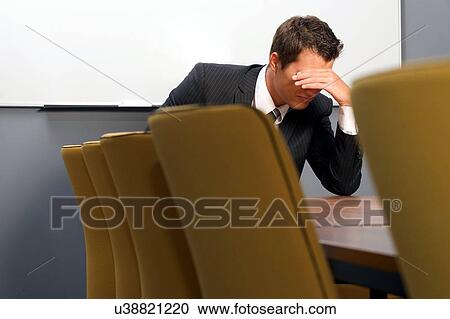 Despaired businessman sitting in office View Large Photo Image Stock Image - Despaired businessman sitting in office. Fotosearch
