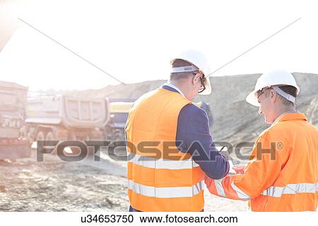 Engineers writing on clipboard at construction site against clear sky View Large Photo Image Stock Image - Engineers writing on clipboard at construction site against clear sky. Fotosearch