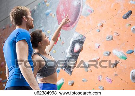 Friends discussing by climbing wall in crossfit gym View Large Photo Image Stock Photo - Friends discussing by climbing wall in crossfit gym. Fotosearch