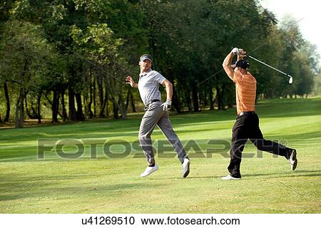 Stock Image - Friends having fun in golf course. Fotosearch