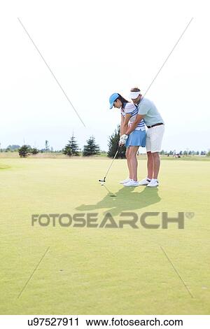 Full length of couple playing golf at course against clear sky View Large Photo Image Stock Image - Full length of couple playing golf at course against clear sky. Fotosearch