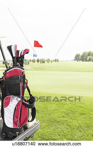 Stock Image - Golf club bag at golf course against clear sky. Fotosearch