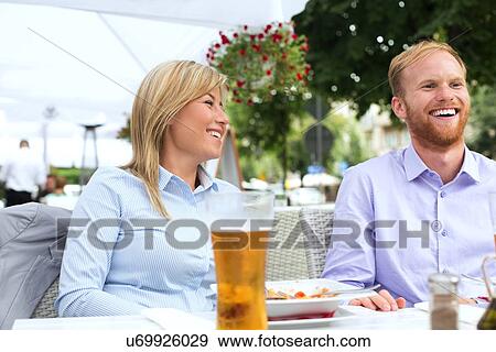 Happy businessman and businesswoman sitting at outdoor restaurant View Large Photo Image Stock Photo - Happy businessman and businesswoman sitting at outdoor restaurant. Fotosearch