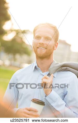 Happy businessman holding disposable cup outdoors View Large Photo Image Stock Image - Happy businessman holding disposable cup outdoors. Fotosearch
