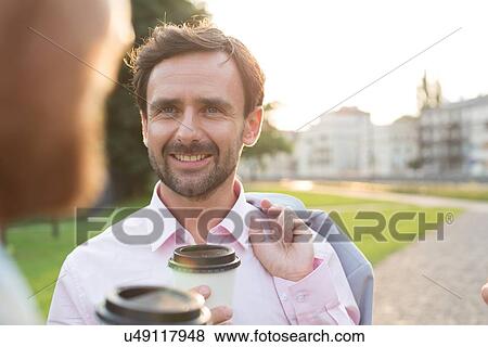 Happy businessman with colleague at park on sunny day View Large Photo Image Stock Photo - Happy businessman with colleague at park on sunny day. Fotosearch