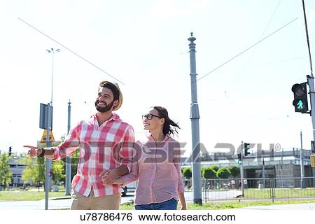 Happy couple walking in city against clear sky View Large Photo Image Stock Photograph - Happy couple walking in city against clear sky. Fotosearch