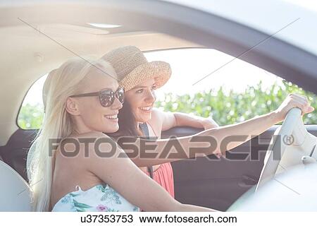 Happy female friends enjoying in car on sunny day View Large Photo Image Stock Image - Happy female friends enjoying in car on sunny day. Fotosearch