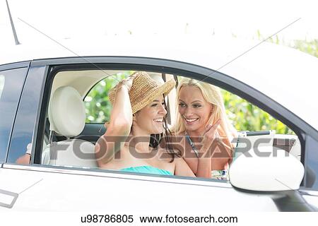 Happy female friends using digital tablet in car on sunny day View Large Photo Image Stock Photography - Happy female friends using digital tablet in car on sunny day. Fotosearch
