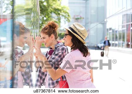 Happy female friends window shopping in city View Large Photo Image Picture - Happy female friends window shopping in city. Fotosearch