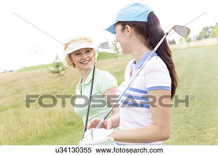 Happy female golfers talking at golf course View Large Photo Image Stock Photography - Happy female golfers talking at golf course. Fotosearch