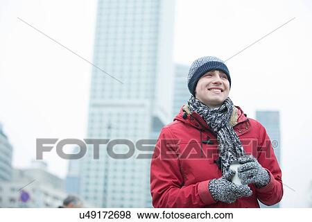 Happy man in warm clothing holding disposable cup outdoors View Large Photo Image Stock Photo - Happy man in warm clothing holding disposable cup outdoors. Fotosearch