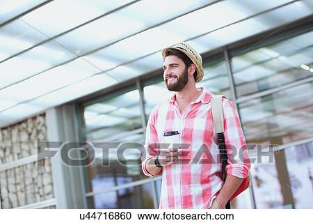 Happy man looking away while holding disposable cup in city View Large Photo Image Stock Image - Happy man looking away while holding disposable cup in city. Fotosearch