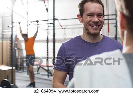 Happy man talking to male friend in crossfit gym View Large Photo Image Picture - Happy man talking to male friend in crossfit gym. Fotosearch