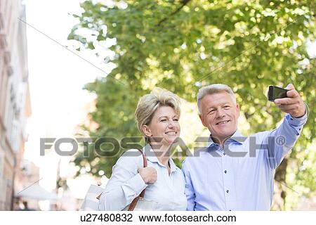 Happy middle-aged couple taking selfie outdoors View Large Photo Image Stock Image - Happy middle-aged couple taking selfie outdoors. Fotosearch