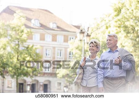 Happy middle-aged couple walking in city View Large Photo Image Stock Image - Happy middle-aged couple walking in city. Fotosearch