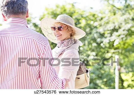Happy middle-aged woman with man in park View Large Photo Image Stock Photograph - Happy middle-aged woman with man in park. Fotosearch