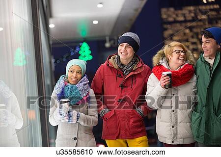 Happy multiethnic friends in winter wear walking in city during dusk View Large Photo Image Stock Image - Happy multiethnic friends in winter wear walking in city during dusk. Fotosearch