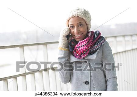 Happy woman in winter wear using cell phone outdoors View Large Photo Image Picture - Happy woman in winter wear using cell phone outdoors. Fotosearch