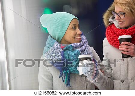 Happy women looking at each other while holding disposable cups View Large Photo Image Stock Image - Happy women looking at each other while holding disposable cups. Fotosearch