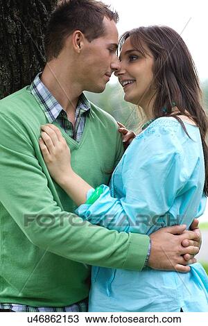 Happy young couple by tree View Large Photo Image Stock Image - Happy young couple by tree. Fotosearch