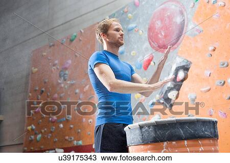 Low angle view of confident man dusting powder by climbing wall in crossfit gym View Large Photo Image Stock Image - Low angle view of confident man dusting powder by climbing wall in crossfit gym. Fotosearch