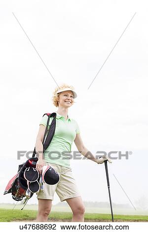 Low angle view of smiling female golfer standing against clear sky View Large Photo Image Stock Image - Low angle view of smiling female golfer standing against clear sky. Fotosearch