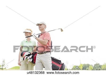 Low angle view of smiling golfers standing against clear sky View Large Photo Image Stock Photo - Low angle view of smiling golfers standing against clear sky. Fotosearch
